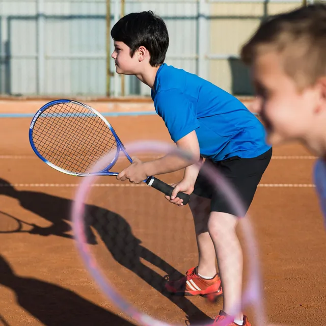 A boy getting ready to hit on a clay tennis court
