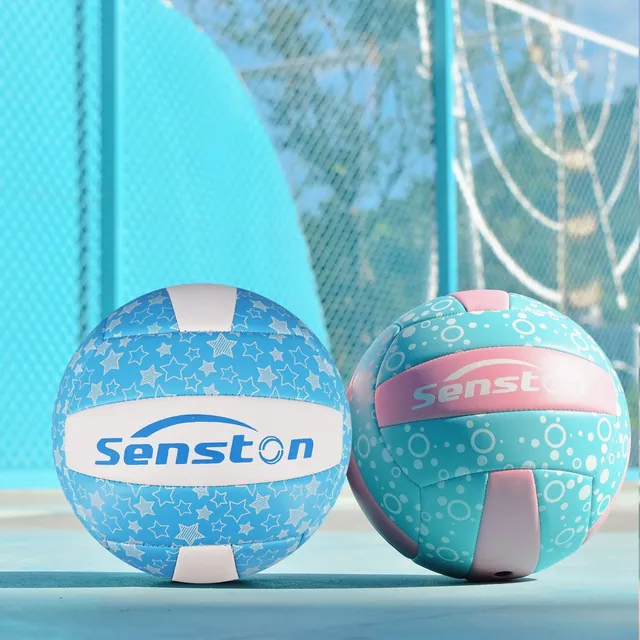 Two star-print volleyballs resting beside a swimming pool